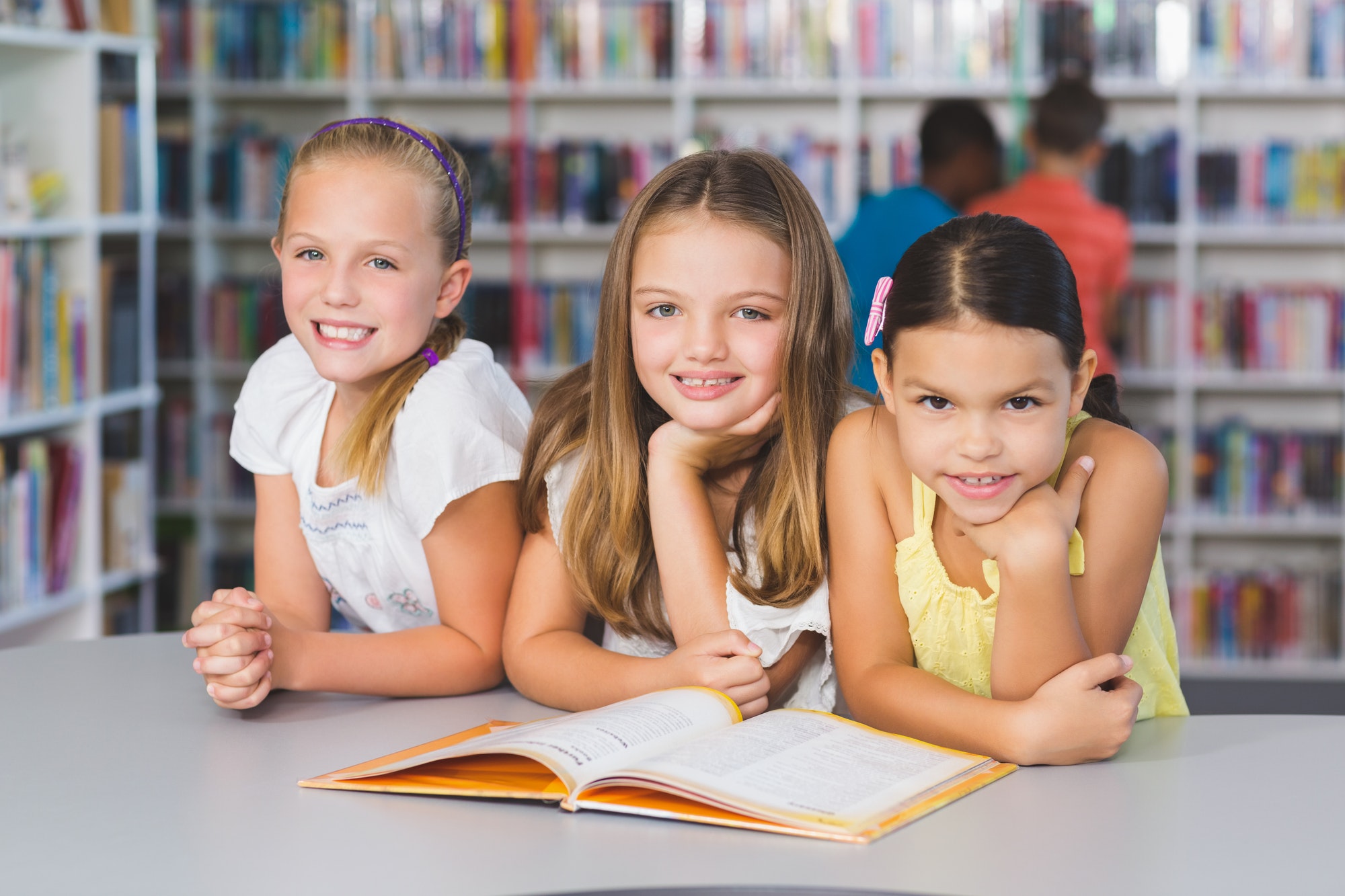 school-kids-reading-book-together-in-library.jpg
